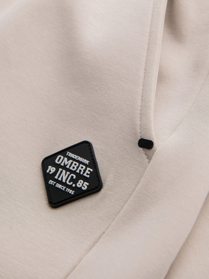 Pánské tepláky s žebrovanými manžetami a ozdobným zipem - pískové V6 OM-PASK-0226