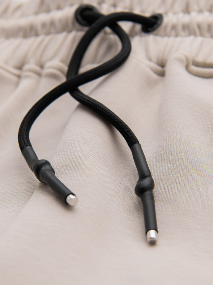 Pánské tepláky s žebrovanými manžetami a ozdobným zipem - pískové V6 OM-PASK-0226